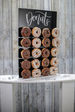 Load image into Gallery viewer, Black Acrylic Donut Wall, with Gold or Silver Donut Text. 43cm x 65cm. Holds 20-40 Donuts. Freestanding