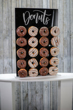 Load image into Gallery viewer, Black Acrylic Donut Wall, with Gold or Silver Donut Text. 43cm x 65cm. Holds 20-40 Donuts. Freestanding